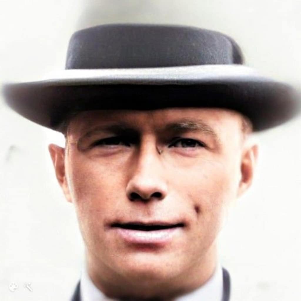 A young man with a gray fedora hat on.