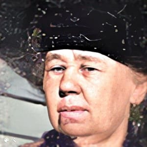 A head shot of a elderly woman with a black hat on.