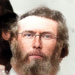 A portrait of a man with redish hair and beard,wearing glasses.