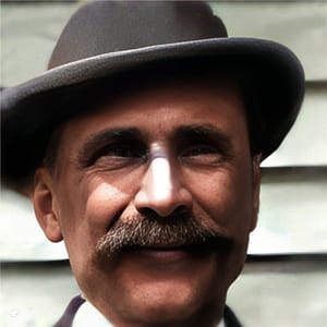 Man wearing a hat. He has a heavy mustache.