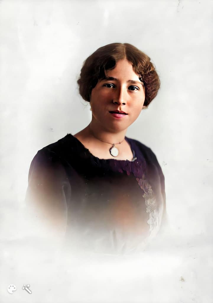 A women with hair parted in the middle and tight waves, a portrait.