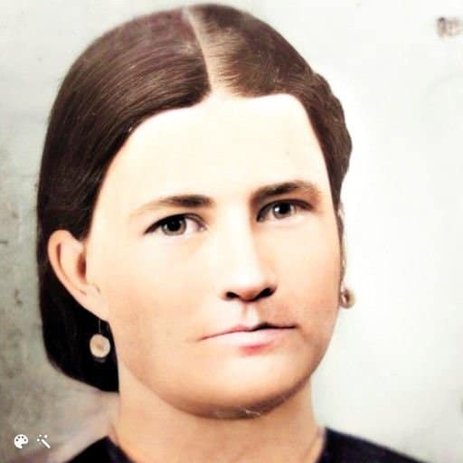 A portrait of a woman with dark hair. The hair is parted in the middle.