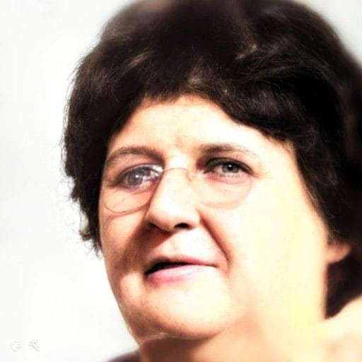 Headshot of a middle aged woman with dark hair and glasses