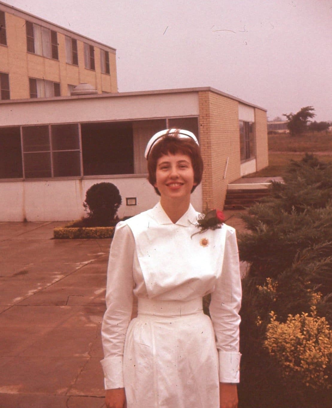 A young woman smiling in a graduation picture from a nursing programme.